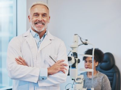 portrait-man-smile-optometrist-with-arms-crossed-hospital-medical-clinic-eye-care-healthcare-vision-happy-confident-proud-senior-male-ophthalmologist-doctor-with-patient